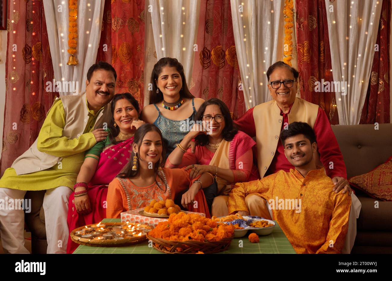 Porträt einer glücklichen indischen Familie in traditionellem Outfit, die Diwali zu Hause gemeinsam feiert Stockfoto