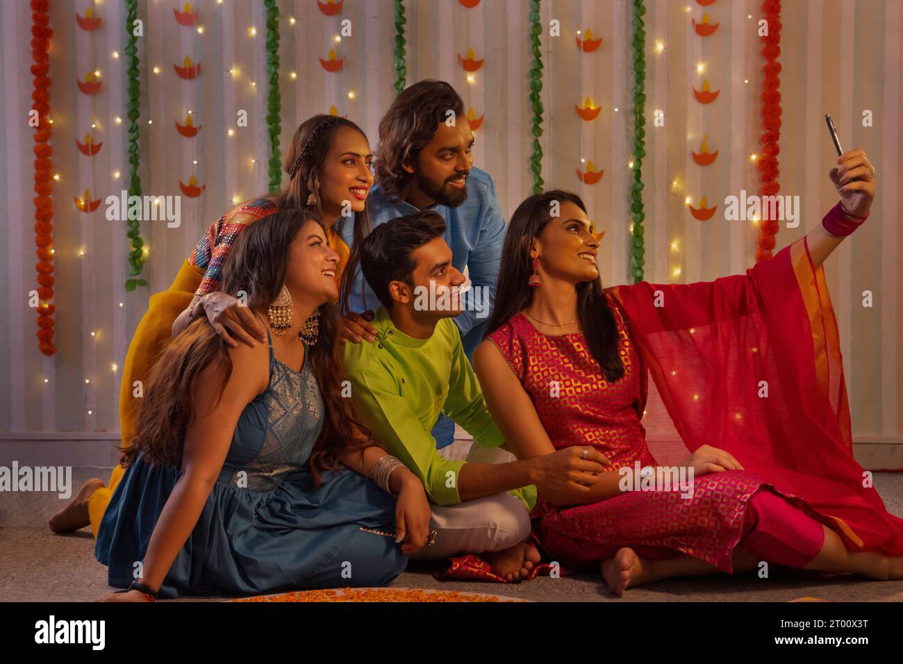 Freunde posieren für eine Gruppe Selfie, während sie Rangoli machen, während Diwali Feiern Stockfoto