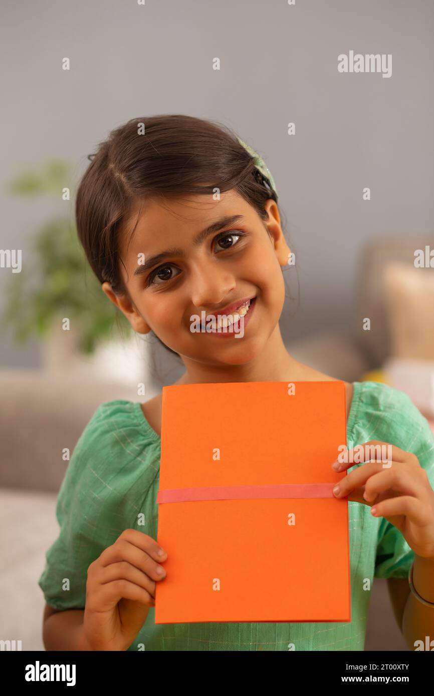 Ein Mädchen, das eine Karte hält, bevor sie beim Festival von Diwali malen wird Stockfoto
