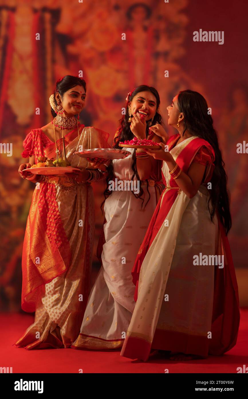 Mutter und Töchter stehen mit Puja-Thali während der Durga-Puja-Feier Stockfoto