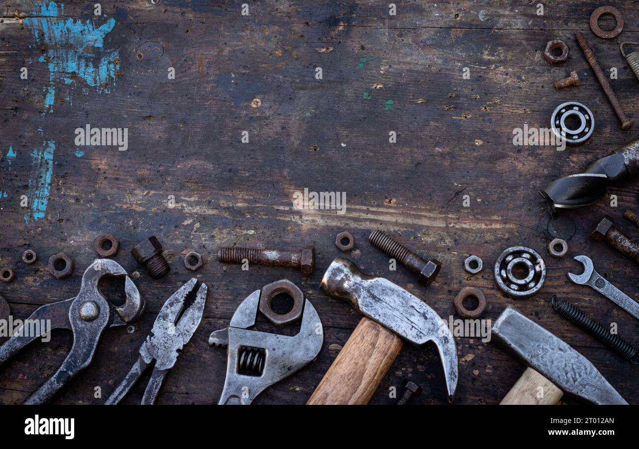 Alte Arbeitsgeräte Muttern, Schrauben und Lager liegen auf einer Holzwerkbank Stockfoto