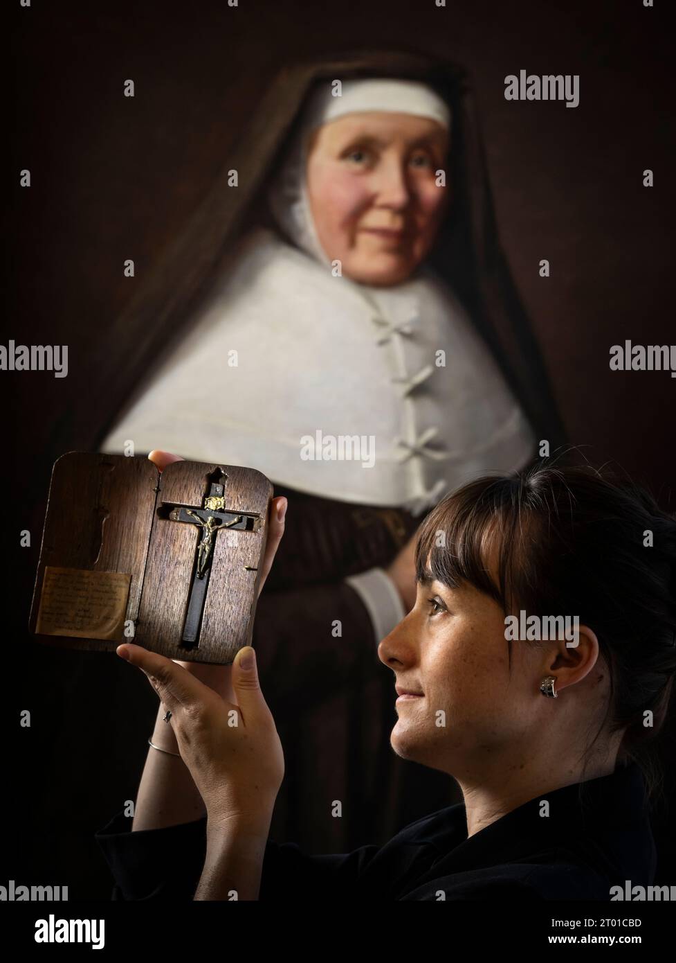 Dr. Hannah Thomas hält ein Kruzifix, das einzige bekannte Objekt, das von den Tausenden überlebt wurde, die während der Überfälle auf katholische Häuser nach der Entdeckung des Gunpowder Plot im Jahr 1605 beschlagnahmt wurden. the Aftermath of the Gunpowder Plot', einer neuen Ausstellung im Bar Convent Heritage Centre in York. Das Kruzifix gehörte Pater Edward Oldcorne, der, obwohl er unschuldig befunden wurde, irgendeine Beteiligung am Plot zu verüben, 1606 gehängt, gezogen und geviertelt wurde, weil er Priester war - ein Hochverrat zu dieser Zeit. Bilddatum: Dienstag, 3. Oktober 2023. Stockfoto