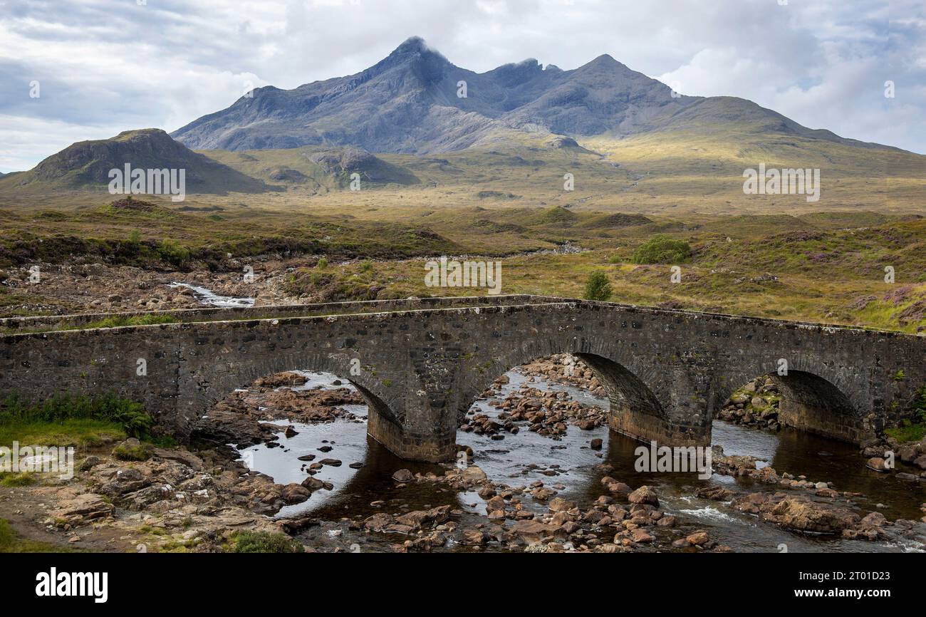 Die alte Brücke in Sligachan, mit dem schwarzen vulkanischen Cullins im Hintergrund. Stockfoto