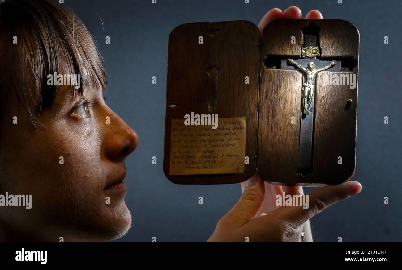 Dr. Hannah Thomas hält ein Kruzifix, das einzige bekannte Objekt, das von den Tausenden überlebt wurde, die während der Überfälle auf katholische Häuser nach der Entdeckung des Gunpowder Plot im Jahr 1605 beschlagnahmt wurden. the Aftermath of the Gunpowder Plot', einer neuen Ausstellung im Bar Convent Heritage Centre in York. Das Kruzifix gehörte Pater Edward Oldcorne, der, obwohl er unschuldig befunden wurde, irgendeine Beteiligung am Plot zu verüben, 1606 gehängt, gezogen und geviertelt wurde, weil er Priester war - ein Hochverrat zu dieser Zeit. Bilddatum: Dienstag, 3. Oktober 2023. Stockfoto