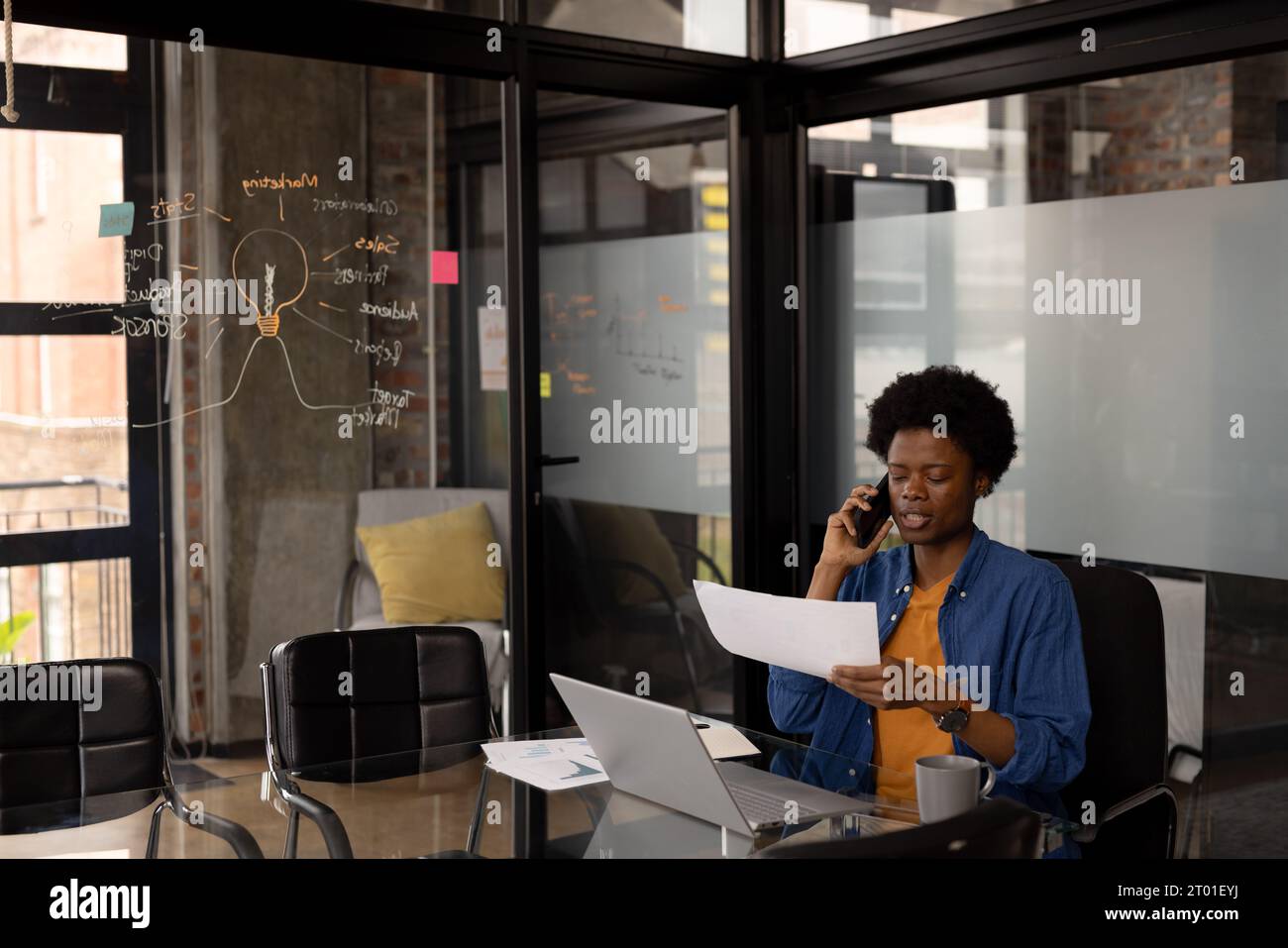 afroamerikanischer Geschäftsmann, der Dokumente hält und telefoniert im Home Office, Kopierraum Stockfoto