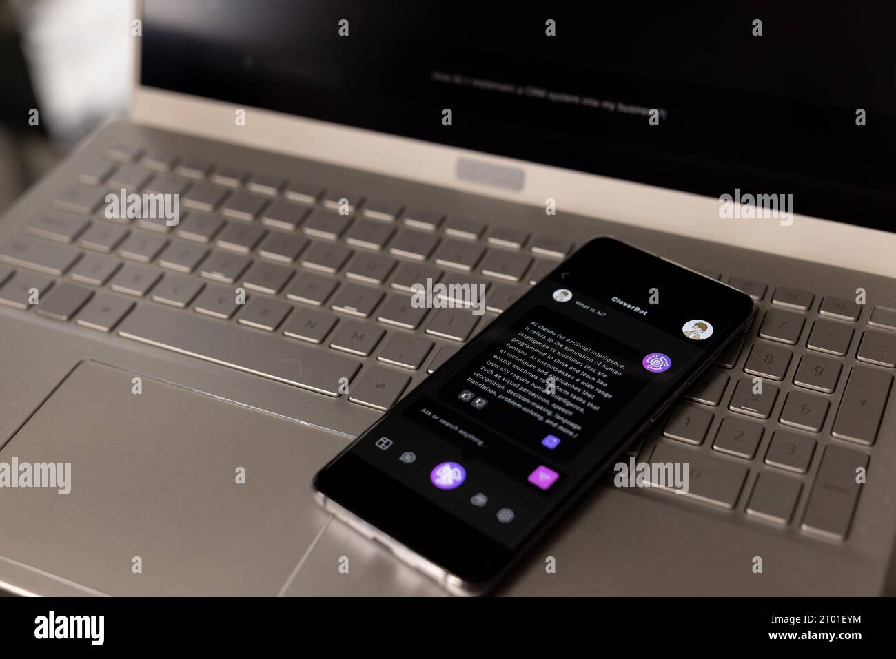Smartphone mit Webchat auf dem Bildschirm, das im Home Office auf der Laptop-Tastatur liegt Stockfoto