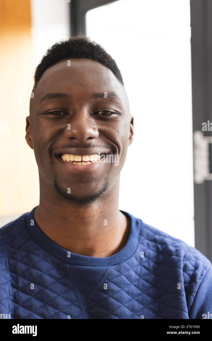 Porträt eines glücklichen afroamerikanischen Mannes mit kurzen schwarzen Haaren, die zu Hause lächeln Stockfoto