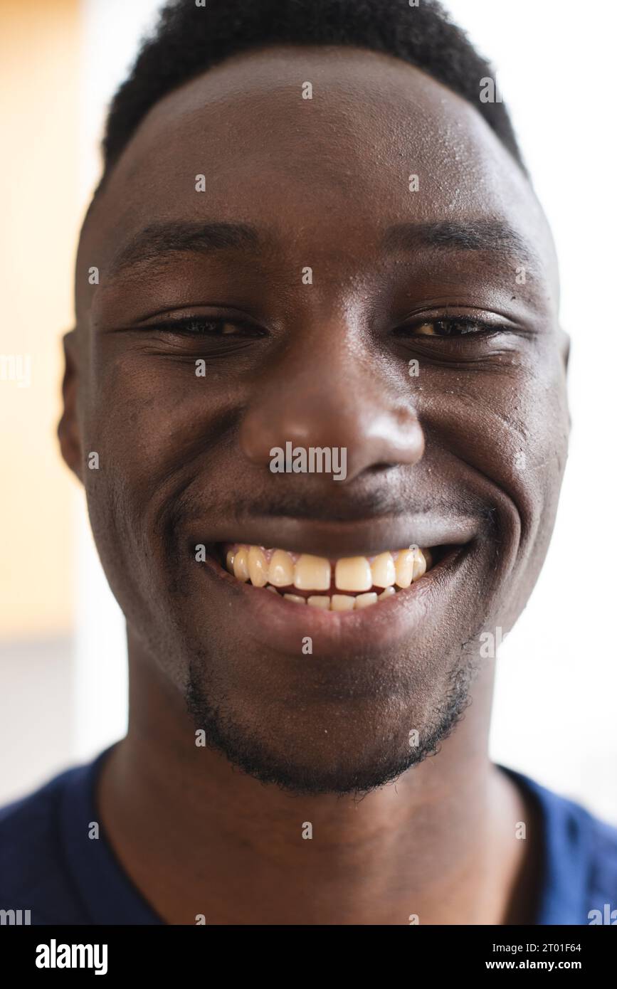 Porträt eines glücklichen afroamerikanischen Mannes mit kurzen schwarzen Haaren, die zu Hause lächeln Stockfoto