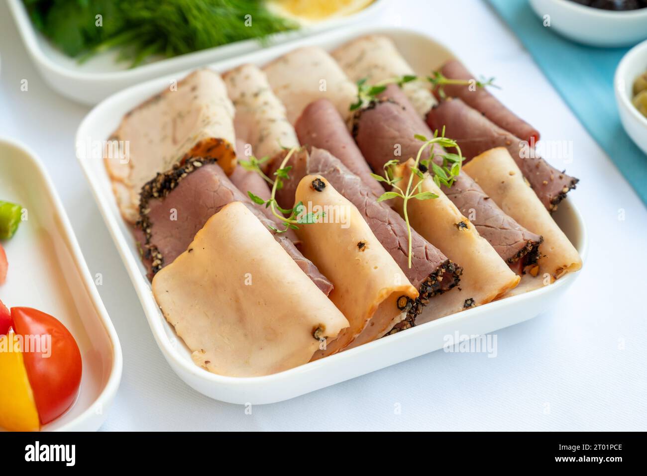 Schinken und Hähnchenschinken mit Pfeffer auf weißem Porzellanteller am Frühstückstisch Stockfoto