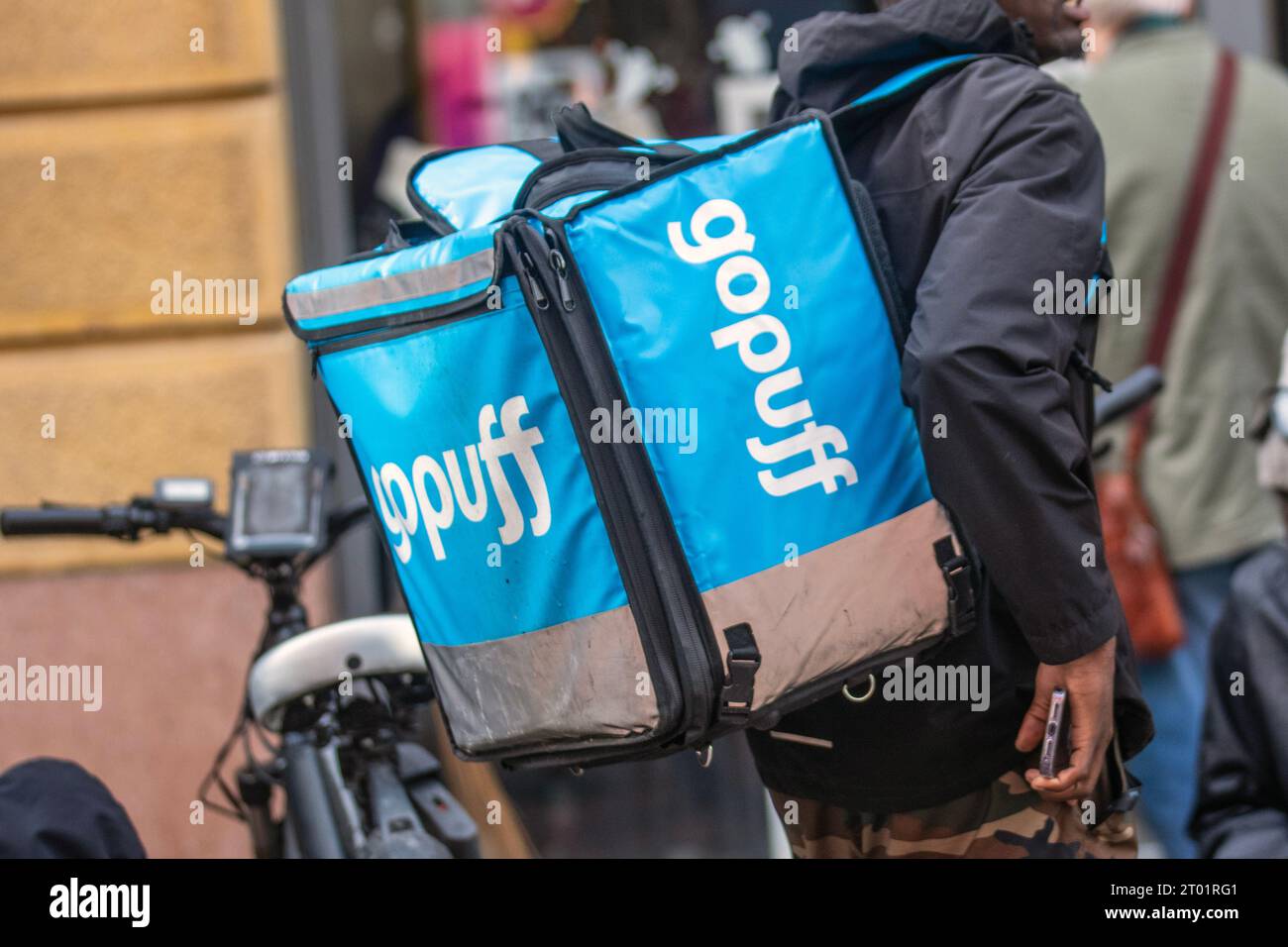 Gopuff Lieferpersonal mit Umhängetasche, Essenslieferung, Essentials, Snacks und Alkohol. Ein amerikanisches Unternehmen für Konsumgüter- und Lebensmittellieferungen in Preston, Großbritannien Stockfoto