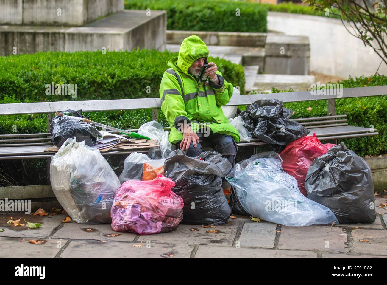 Obdachloser Taschenmann, der auf dem Handy in Preston, Lancashire spricht. Oktober 2021. Ein Obdachloser, der durch die Straßen der Stadt streift und seine Besitztümer in mehreren Taschen trägt. Verzweifelte Obdachlose in Preston kehren auf die Straße zurück, als Notunterkünfte, in denen während der Pandemie raue Schläfer untergebracht wurden, wieder aufgelöst sind. Stockfoto