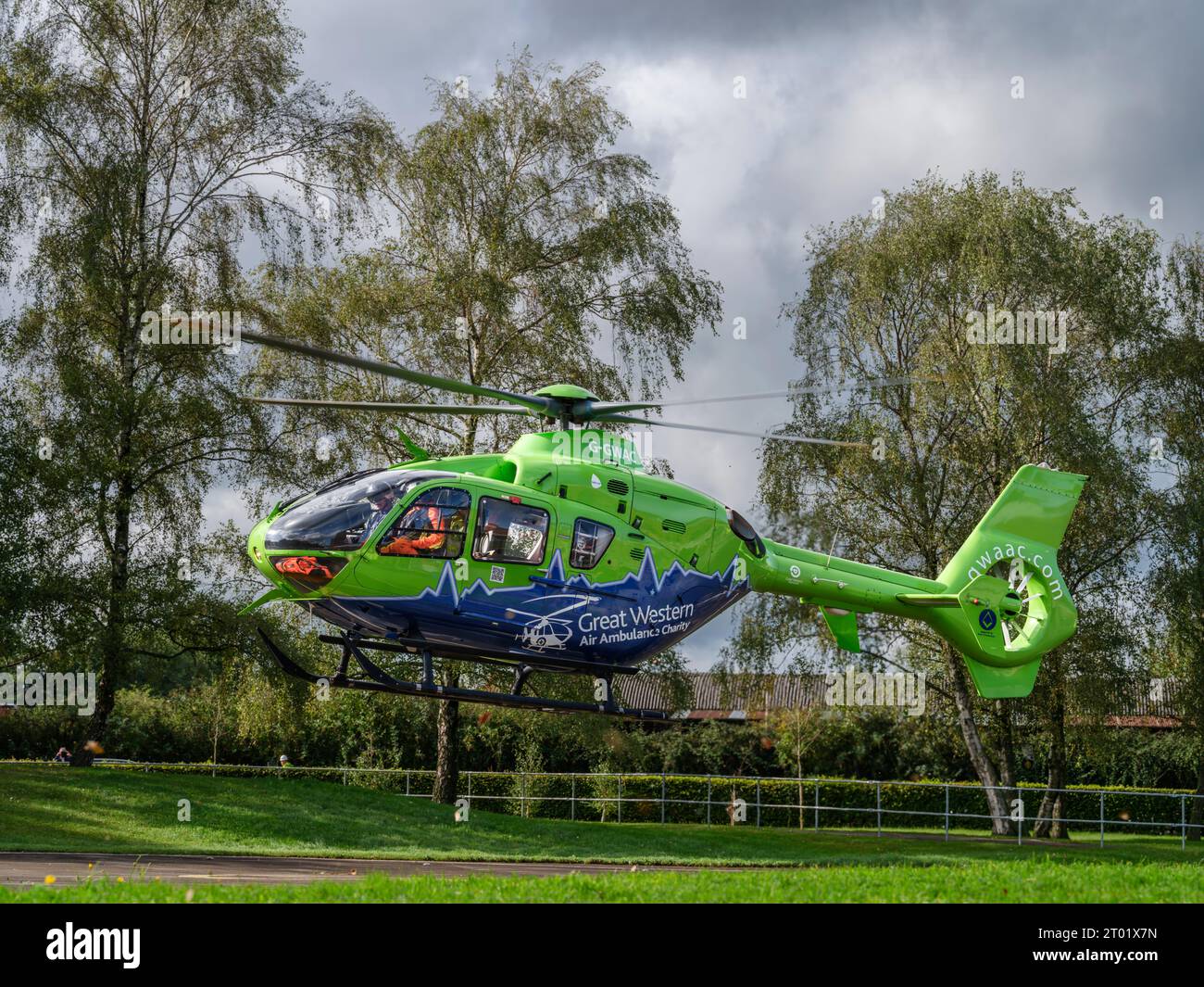 Der Great Western Air Ambulance hebt vor dem Gloucester Royal Hospital ab. Der hellhellhellgrüne und blaue Hubschrauber, Rufzeichen Helimed 65, ist Stockfoto