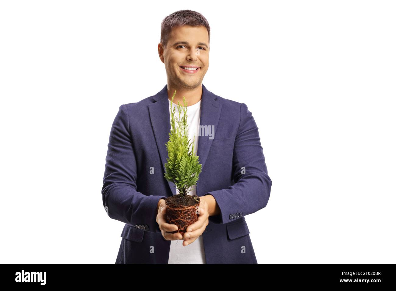 Hübscher, lächelnder junger Mann, der einen kleinen Baum in einem Topf auf weißem Hintergrund hält Stockfoto