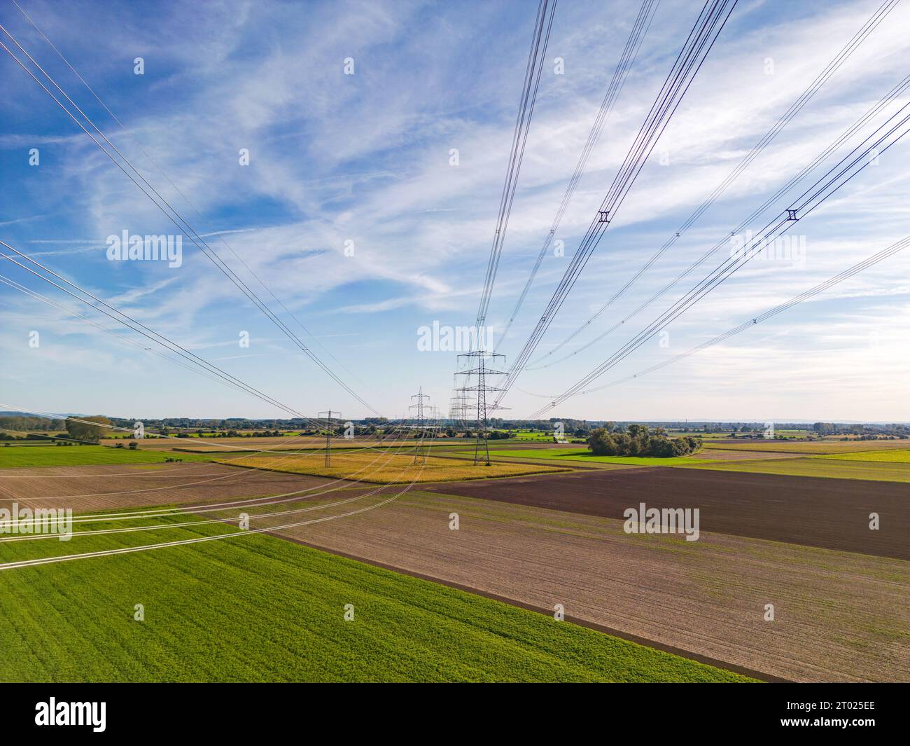 Ländliche Naturlandschaft im Konflikt mit künstlichen Strukturen von Kraftmasten und Stromleitungen für die Konsumgesellschaft als Luftbild Stockfoto