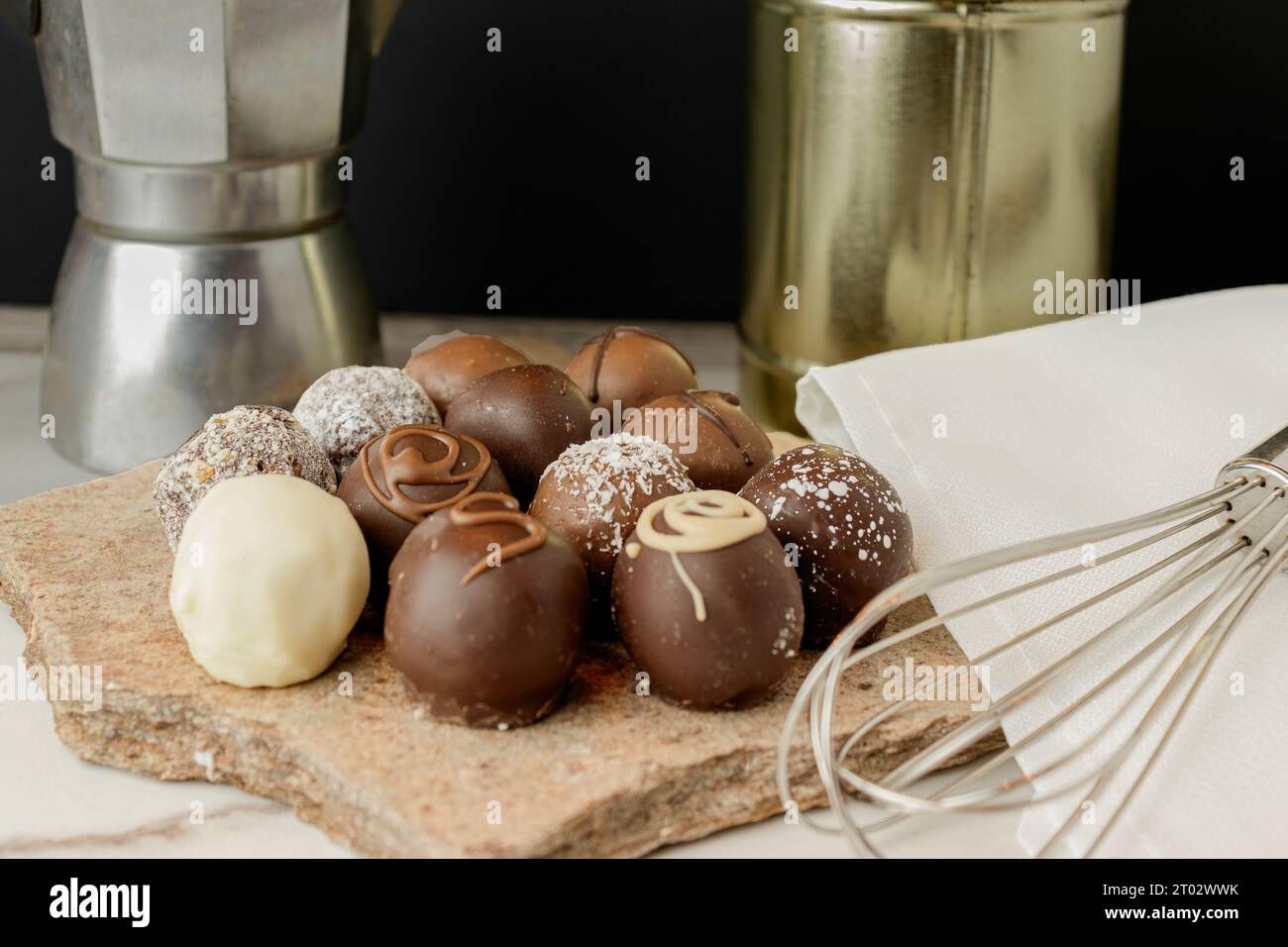 Schokoladentrüffel mit Dulce de leche, Handquirl und alter italienischer Kaffeekanne Stockfoto