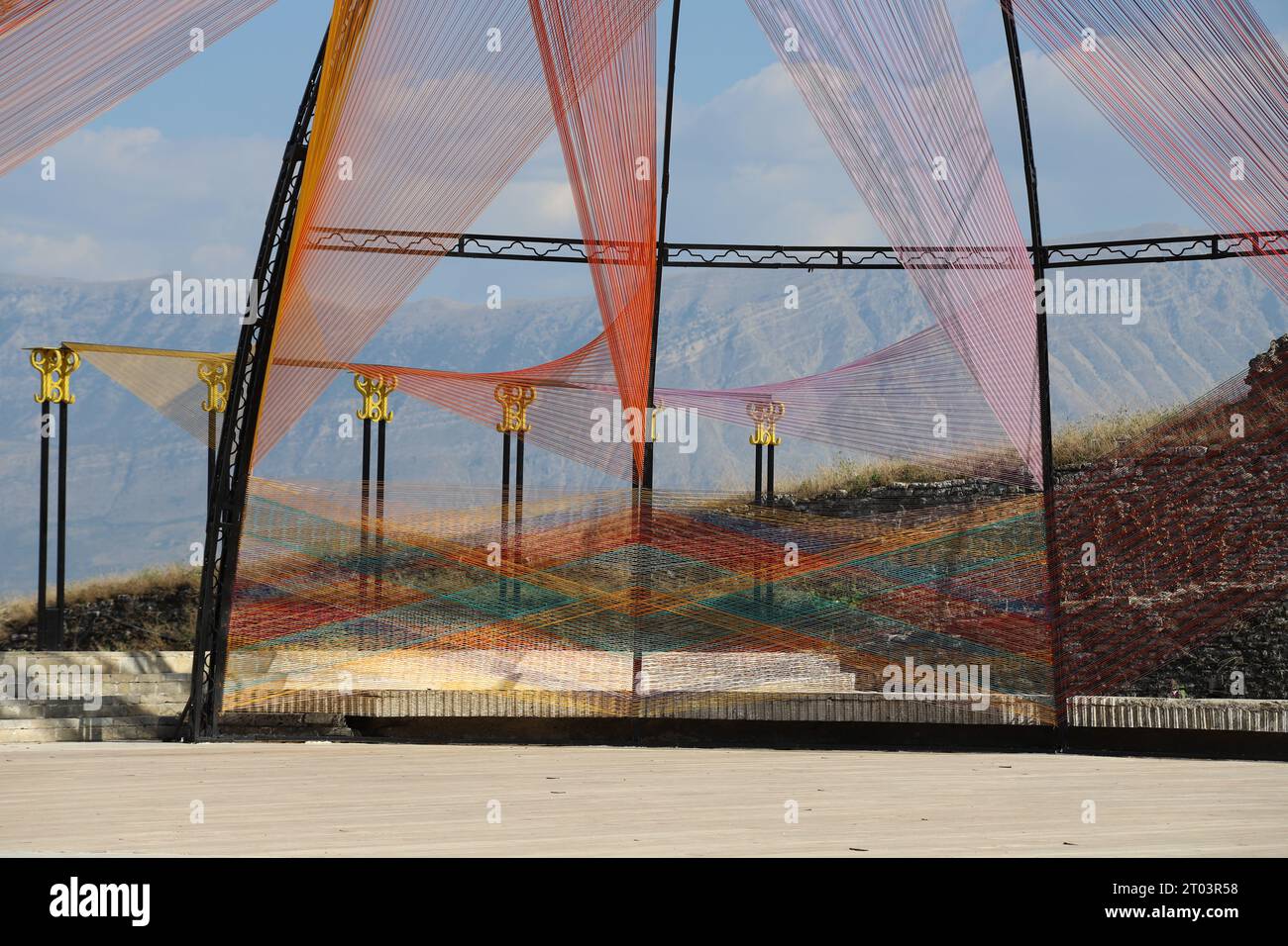 Eine ästhetisch ansprechende Outdoor-Bühne im modernen Art Design, die aus mehrfarbigen, miteinander verwobenen Schnur, Schnur oder Schnur mit Bergkulisse besteht. Stockfoto