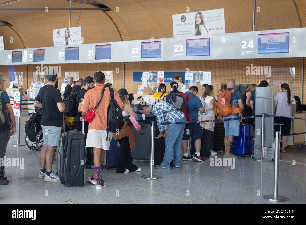 Posen, Polen - 25. August 2023: Personen stehen an den Check-in-Schaltern am Flughafen Posen Lawica an. Stockfoto
