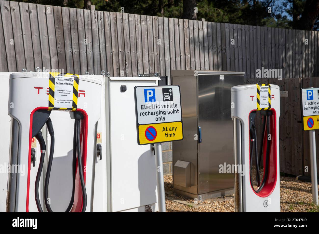 Tesla-Ladegeräte für Elektrofahrzeuge bei Fleet Autobahndiensten in Hampshire, Schilder weisen darauf hin, dass die Ladegeräte nicht für den Einsatz in England, Großbritannien verfügbar sind Stockfoto