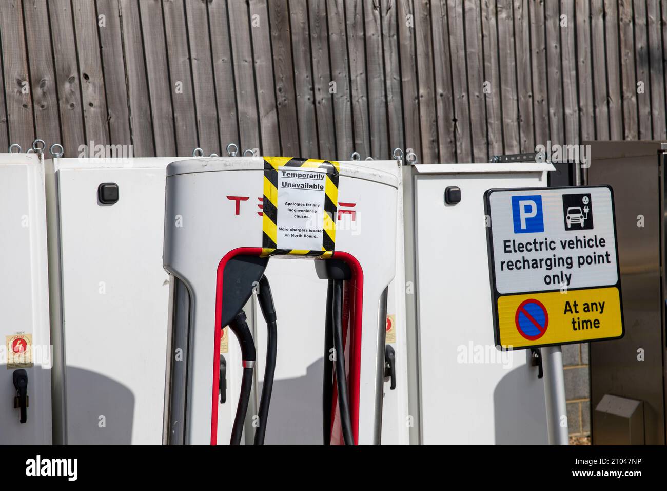 Tesla-Ladegeräte für Elektrofahrzeuge bei Fleet Autobahndiensten in Hampshire, Schilder weisen darauf hin, dass die Ladegeräte nicht für den Einsatz in England, Großbritannien verfügbar sind Stockfoto