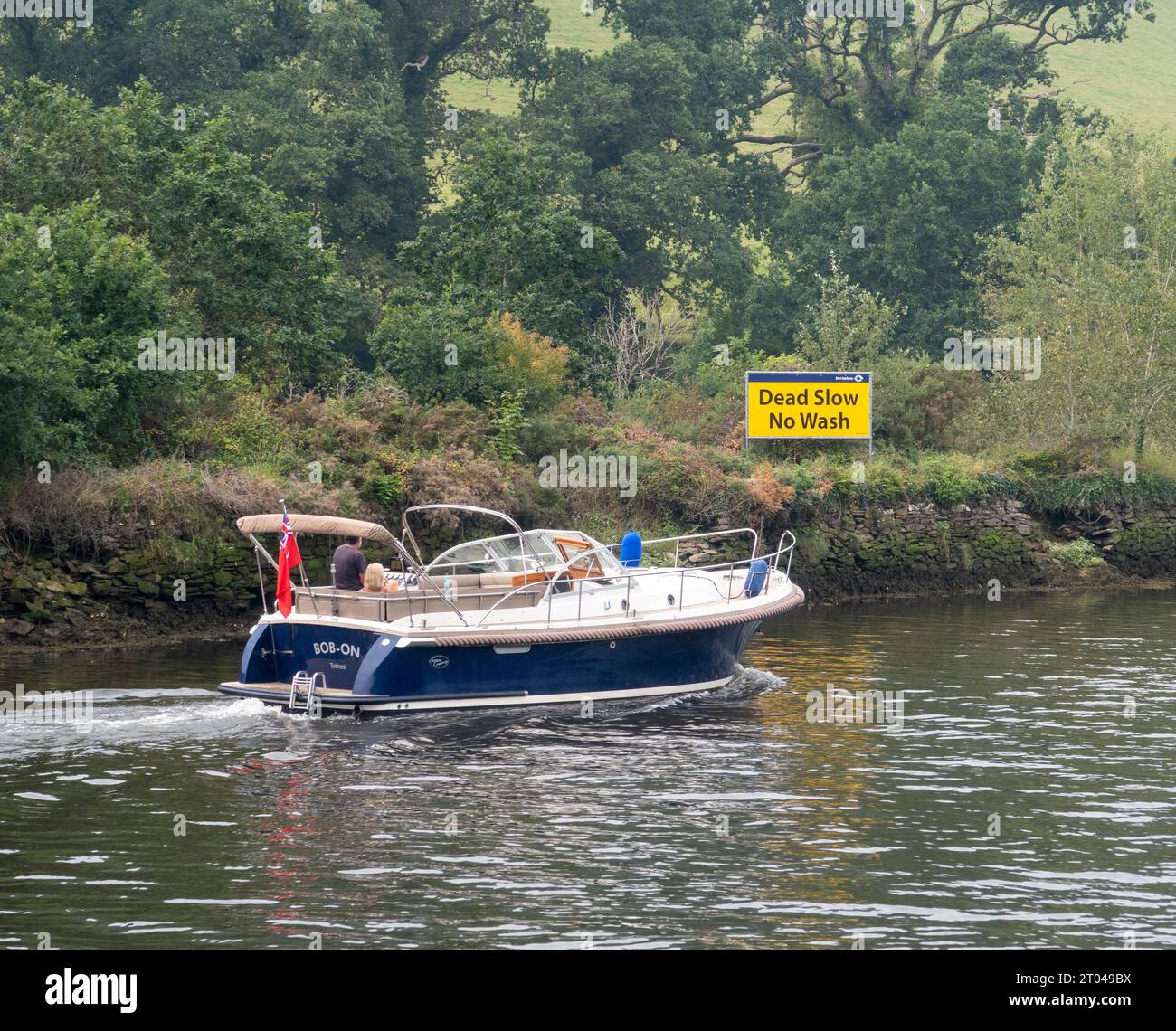 Schild auf dem River Dart - Dead Slow, No Washing. Geschwindigkeitsschild für Boote, Flussverkehr, keine Geschwindigkeitsüberschreitung, Stockfoto
