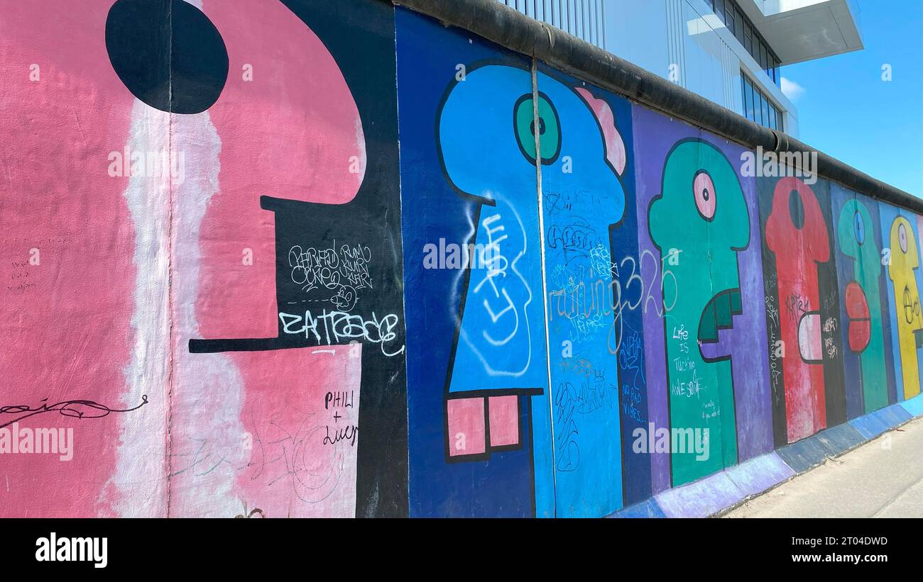Cartoon-Köpfe von Thierry Noir wurden auf der Westseite der Berliner Mauer gemalt Stockfoto