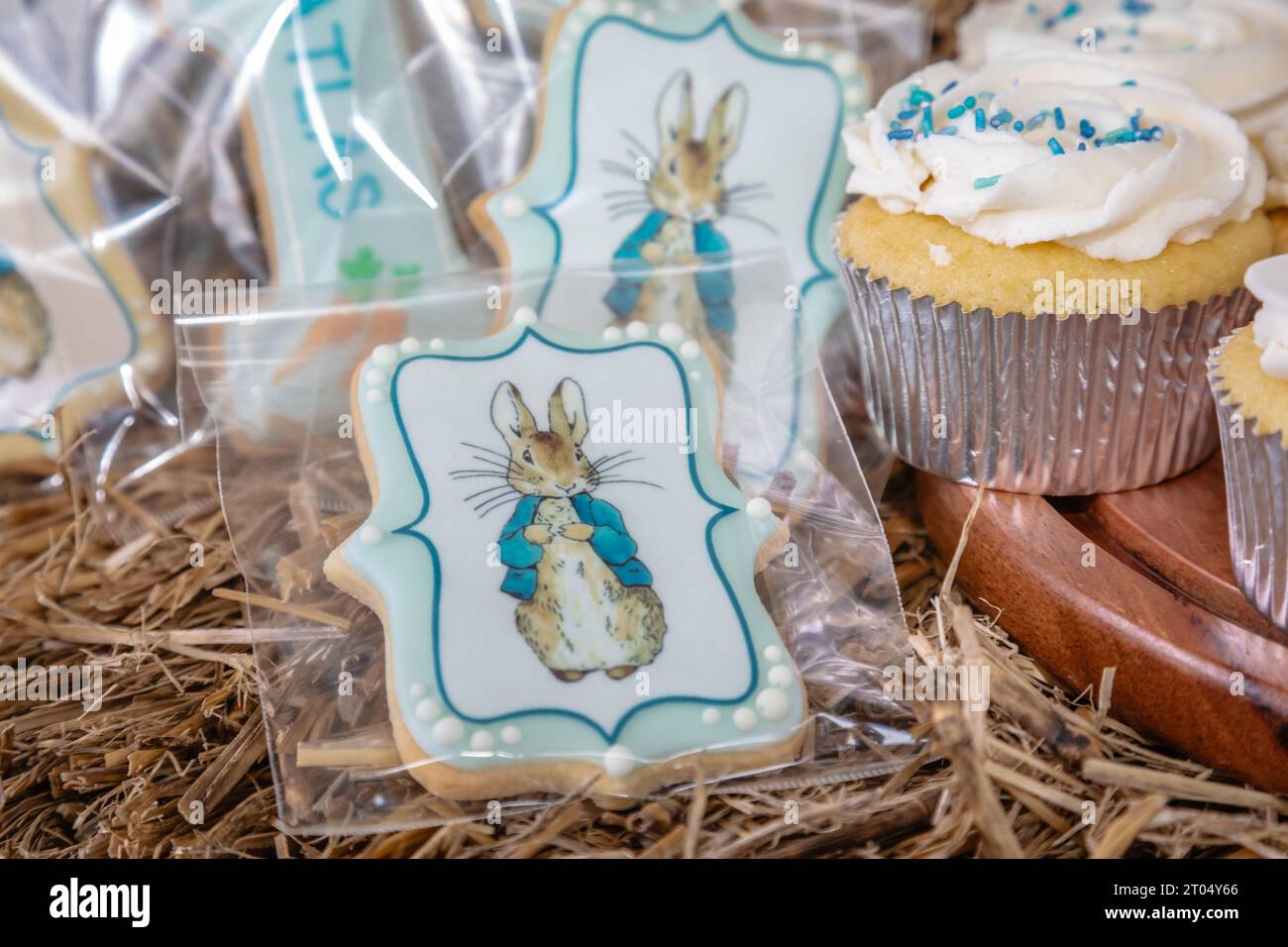 Ein Nahbild eines dekorierten Kekses mit einem charmanten Kaninchen und einem Cupcake, der mit bunten Streuseln verziert ist, die jeweils einen skurrilen Charme ausstrahlen Stockfoto