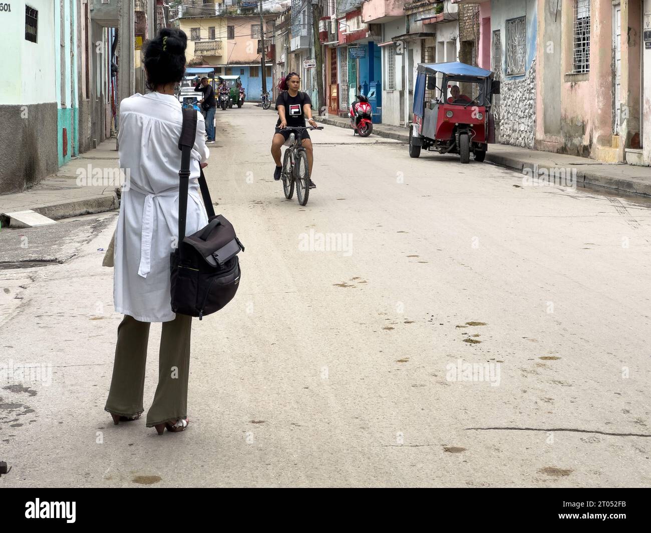 Eine Ärztin trampelt auf einer Straße der Stadt. Sie ist in der Nähe des Alten Krankenhauses. Santa Clara, Kuba, 2023 Stockfoto