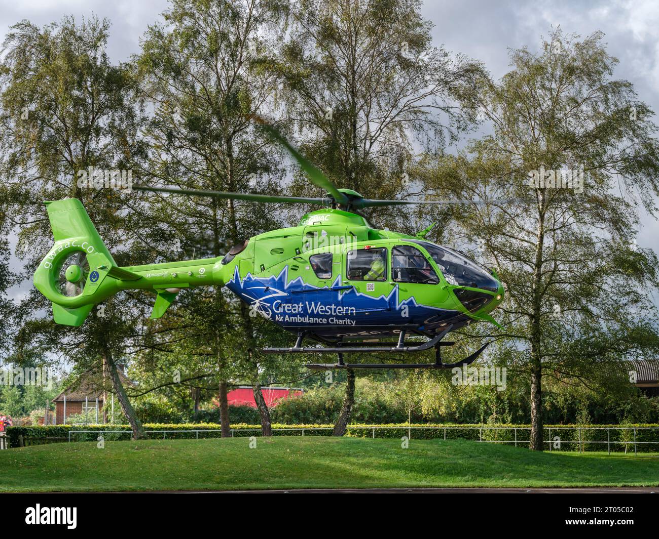 Der Great Western Air Ambulance hebt vor dem Gloucester Royal Hospital ab. Der hellhellhellgrüne und blaue Hubschrauber, Rufzeichen Helimed 65, ist Stockfoto