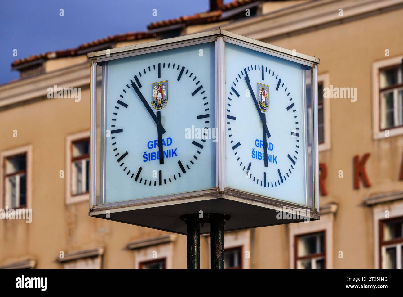 Zwei Gesichter der würfelförmigen Uhr im Art déco-Stil am Hafen von sibenik croatia zeigen sechs bis sechs Minuten Stockfoto