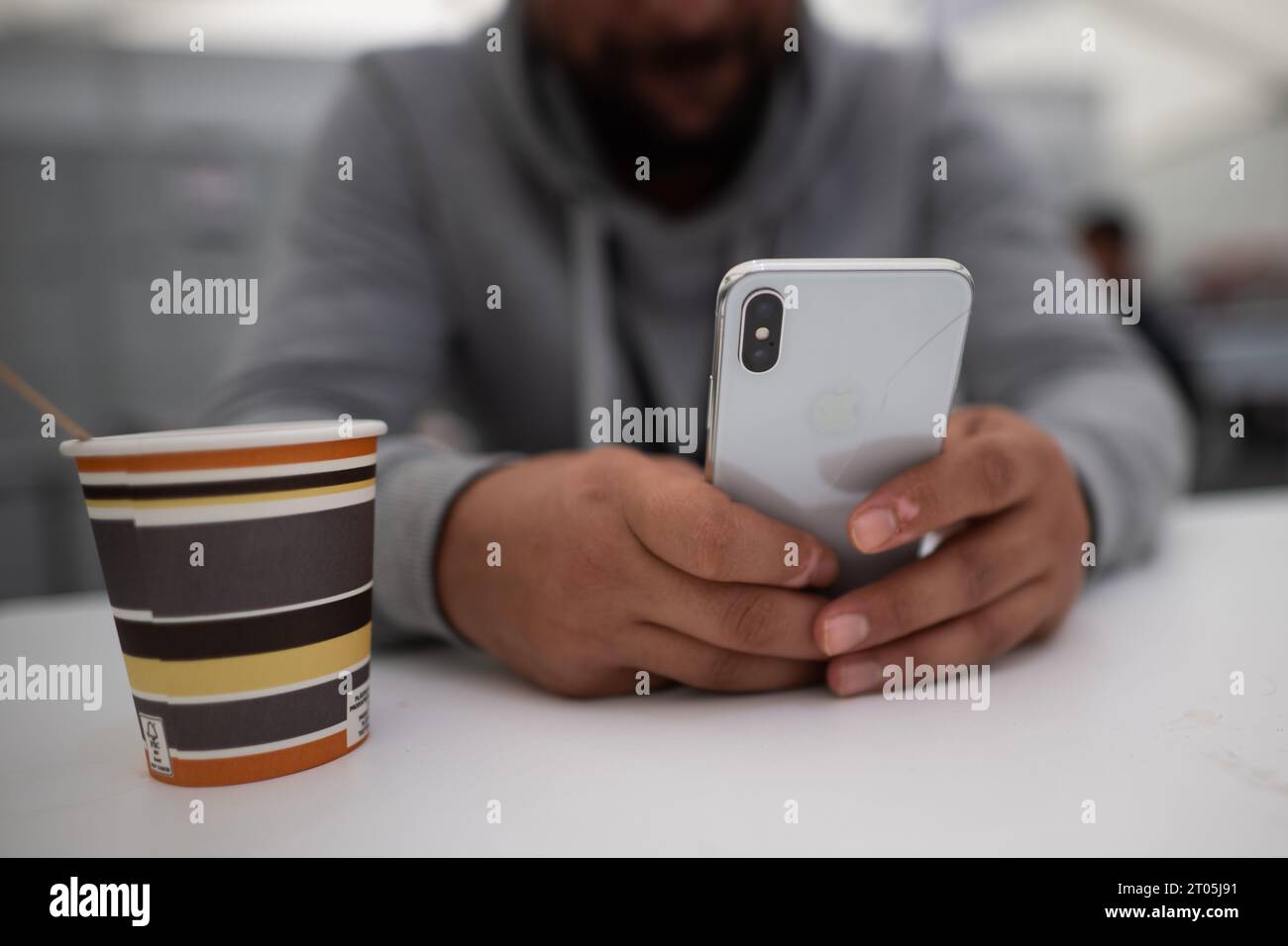 Berlin, Deutschland. Oktober 2023. Ein Mann aus der Türkei lernt Deutsch auf seinem Smartphone im Ankunftszentrum am ehemaligen Flughafen Tegel. Quelle: Sebastian Gollnow/dpa/Alamy Live News Stockfoto