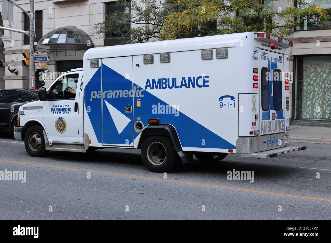 Krankenwagen fährt die Stadtstraße entlang - tagsüber Stockfoto
