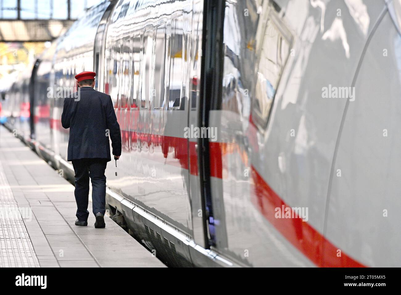 Zugführer, Schaffner, Zugbegleiter geht an einem ICE entlang.Intercity