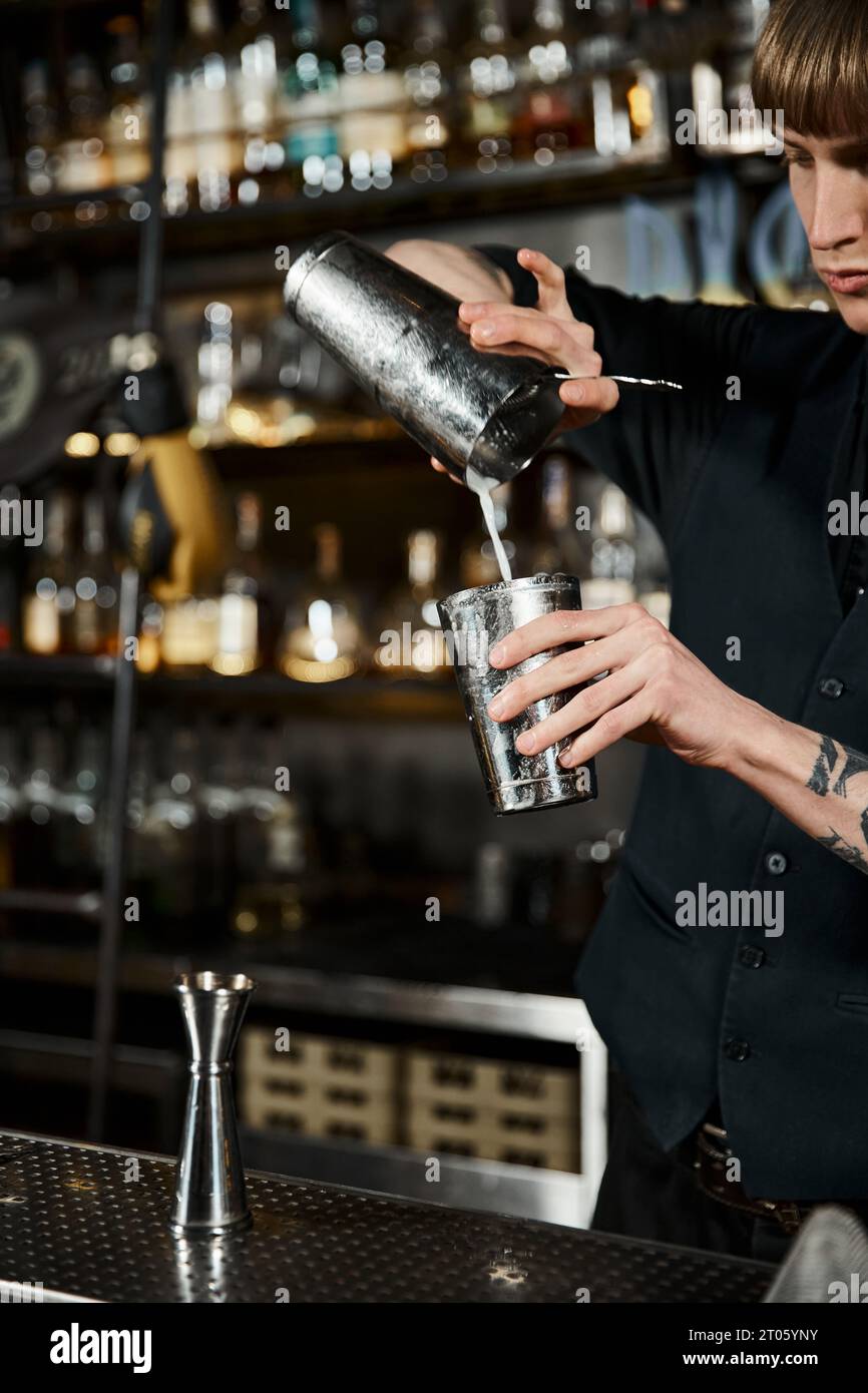 Barkeeper mit Cocktail-Shaker und Milchkrug, der in der Bar ein Craft-Getränk zubereitet, Mixology Artistry Stockfoto