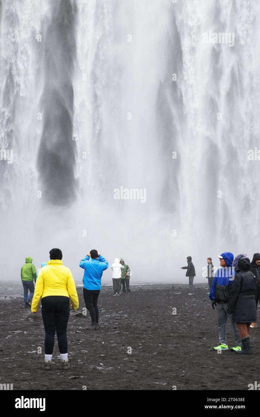 Island Wasserfall - Touristen am Skogafoss Wasserfall, einem von mehreren Wasserfällen auf der Island South Coast Tour, Island, Europa. Reisen Stockfoto