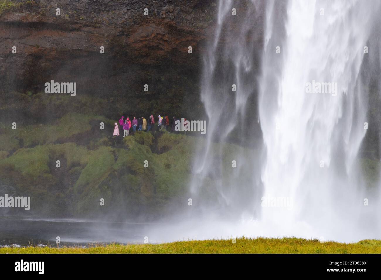 Island Wasserfall; Personen am Seljalandsfoss Wasserfall auf der Golden Circle Tour; Spaziergang hinter dem Wasserfall; Island Travel Stockfoto