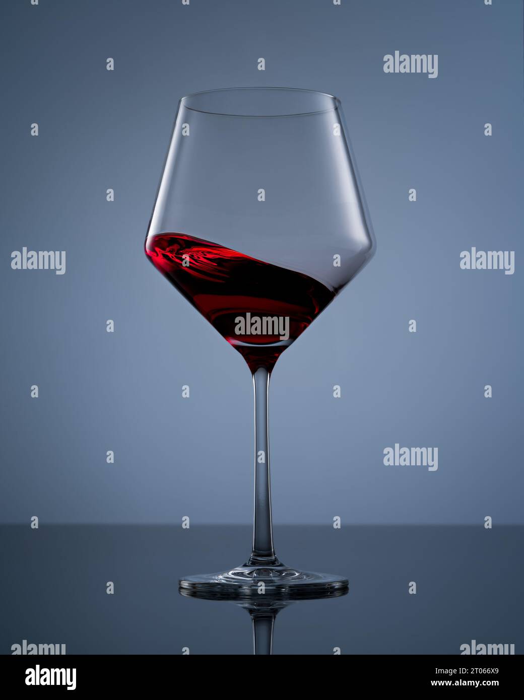 Weinglas mit Rotweinwirbel Stockfoto