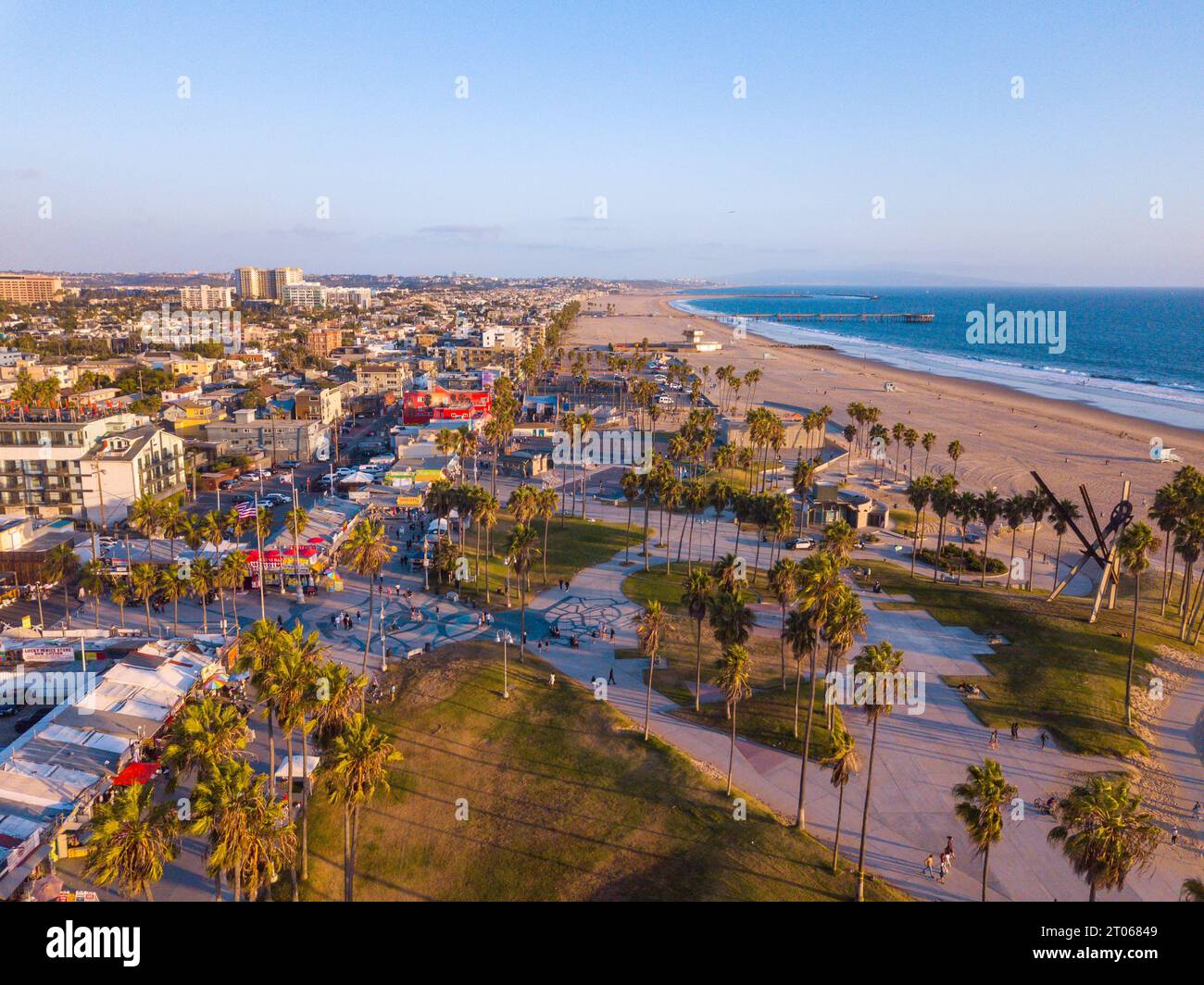 Luftaufnahmen mit einer Drohne während eines Winteruntergangs in Venice Beach, Los Angeles, Kalifornien, auf die Basketballfelder, Palmen und kurvige lan Stockfoto