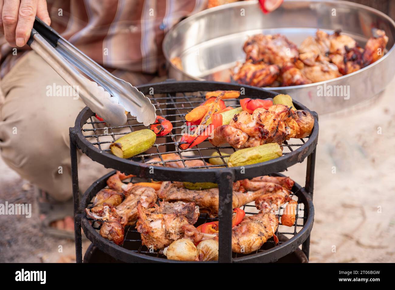 Zurbian Dinner. Das Fass wurde freigelegt und ist fertig und gut gekocht. Es enthält Huhn, Gemüse und Reis. Sie wird auf einem Drahtgestell A platziert Stockfoto