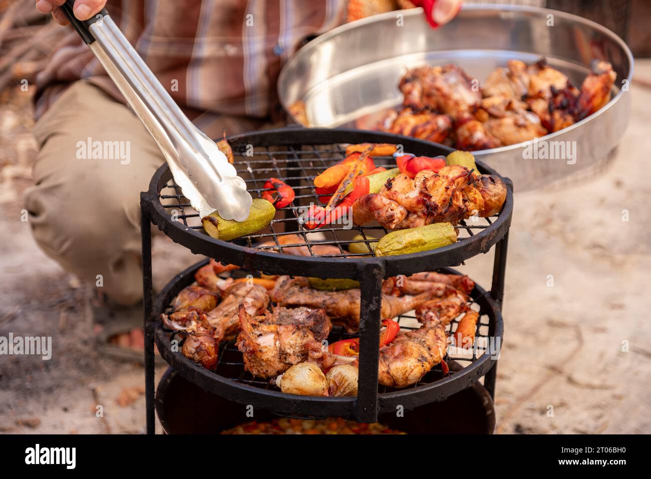 Zurbian Dinner. Das Fass wurde freigelegt und ist fertig und gut gekocht. Es enthält Huhn, Gemüse und Reis. Sie wird auf einem Drahtgestell A platziert Stockfoto