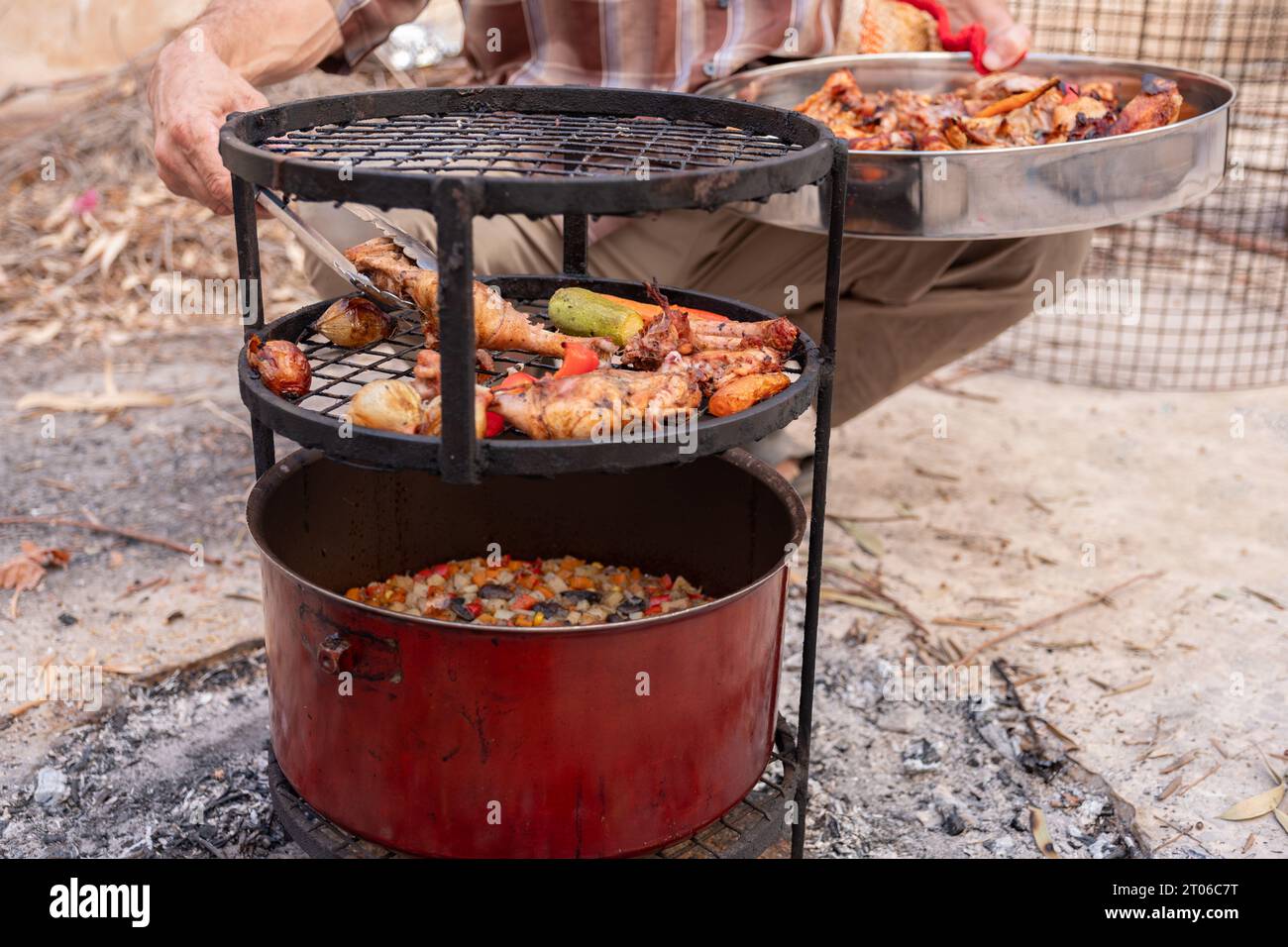 Zurbian Dinner. Das Fass wurde freigelegt und ist fertig und gut gekocht. Es enthält Huhn, Gemüse und Reis. Sie wird auf einem Drahtgestell A platziert Stockfoto
