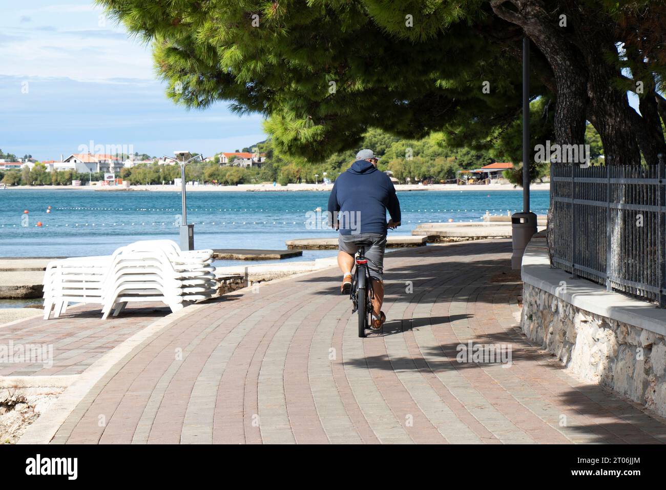 Vodice, Kroatien - 24. September 2023: Radfahrer an der Promenade am Strand am Ende der Saison, von hinten Stockfoto