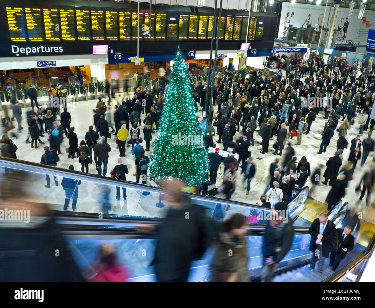 WEIHNACHTSREISE Waterloo Station Halle mit Weihnachtsbaum, Massen von Pendlern und Familien, die sich die Abfahrtsinformationsbildschirme ansehen, Heimfahrt für die Winterweihnachtszeit festliche Reise Waterloo Station London UK Stockfoto