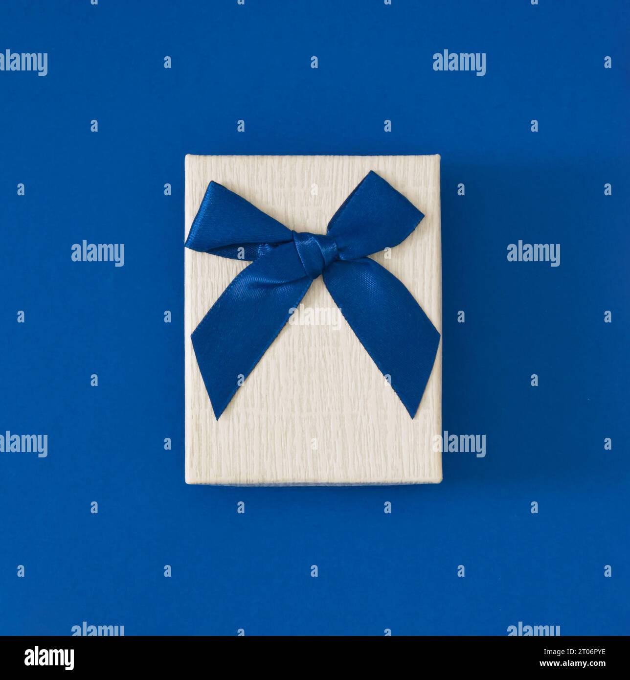 Nahansicht minimale Zusammensetzung der Weihnachtsgeschenkbox auf blauem Hintergrund. Neujahrspräsentation Konzept Hintergrund. Trendige Geschenkbox-Idee. Ästhetische Geschenkbox Stockfoto
