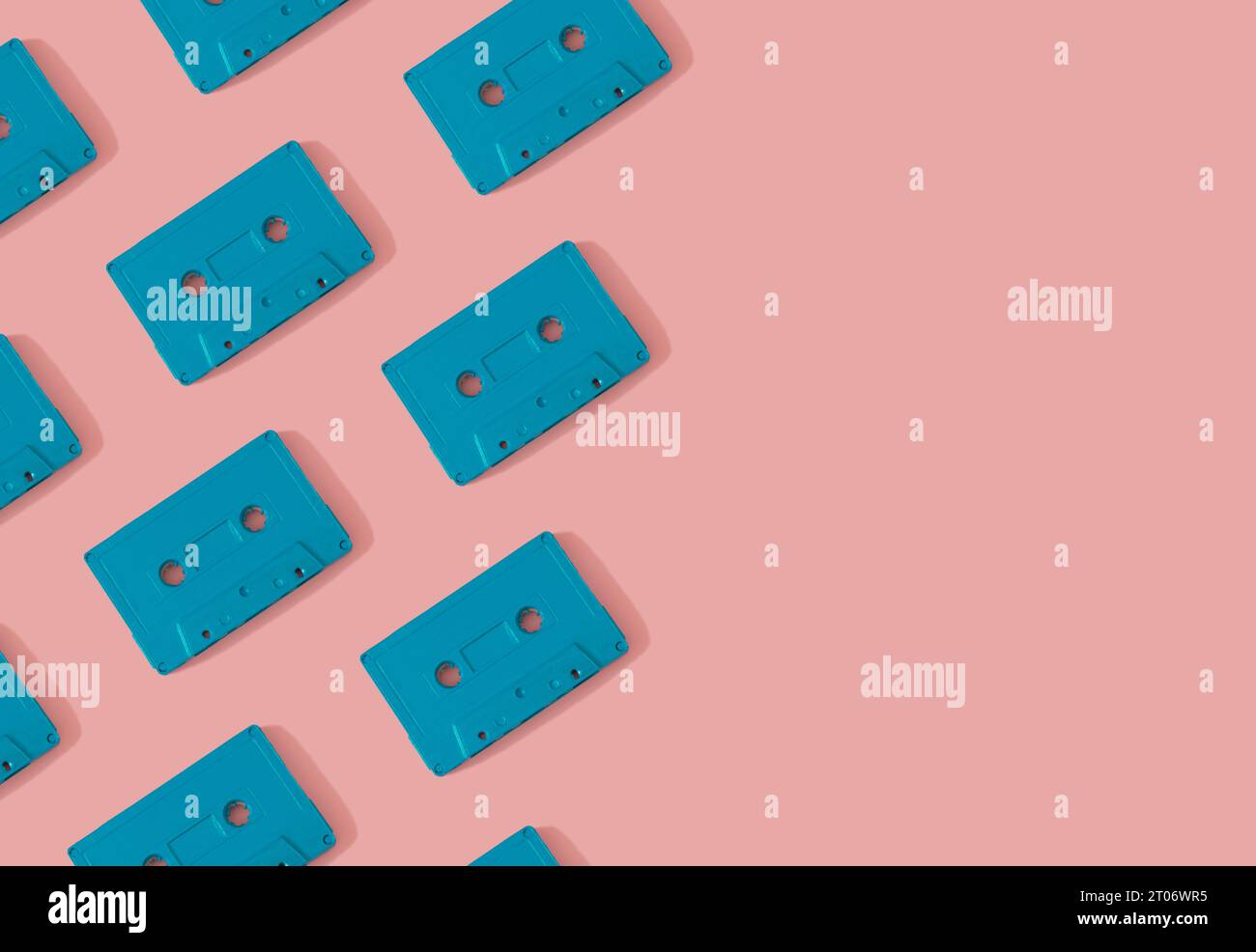 Muster mit blauen Retro-Audiokassetten auf modernem rosa Hintergrund. Kreatives Konzept der Retro-Technologie. Ästhetik der 80er Jahre. Retro-Vintage-Audio Stockfoto