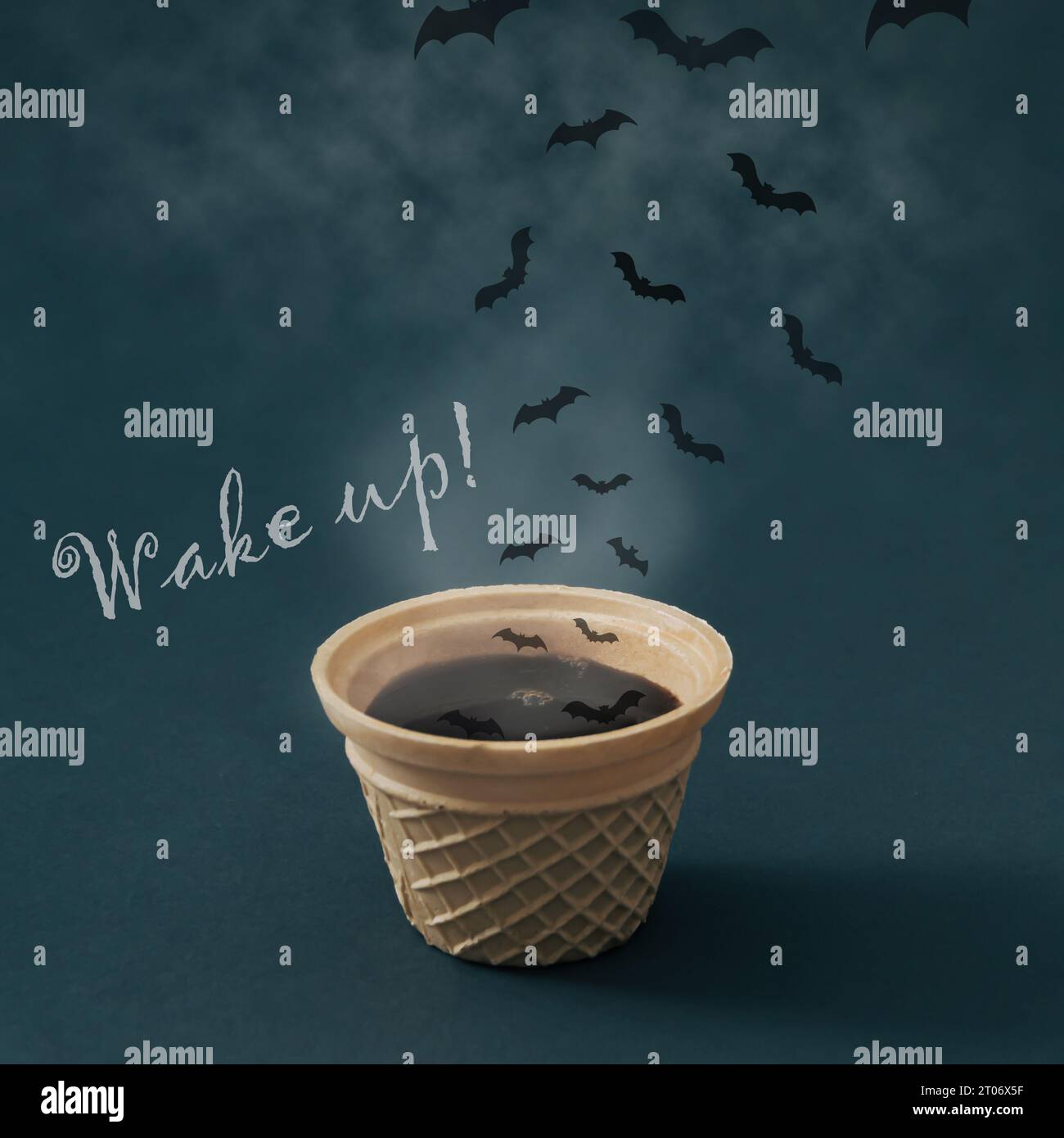 Heißer dampfender Kaffee in Waffeleiskegel, Wolken und Fledermäuse mit „Wake up!“ Nachricht. Minimales Kaffeekonzept. Kreative Idee für Eiskaffee. Stockfoto