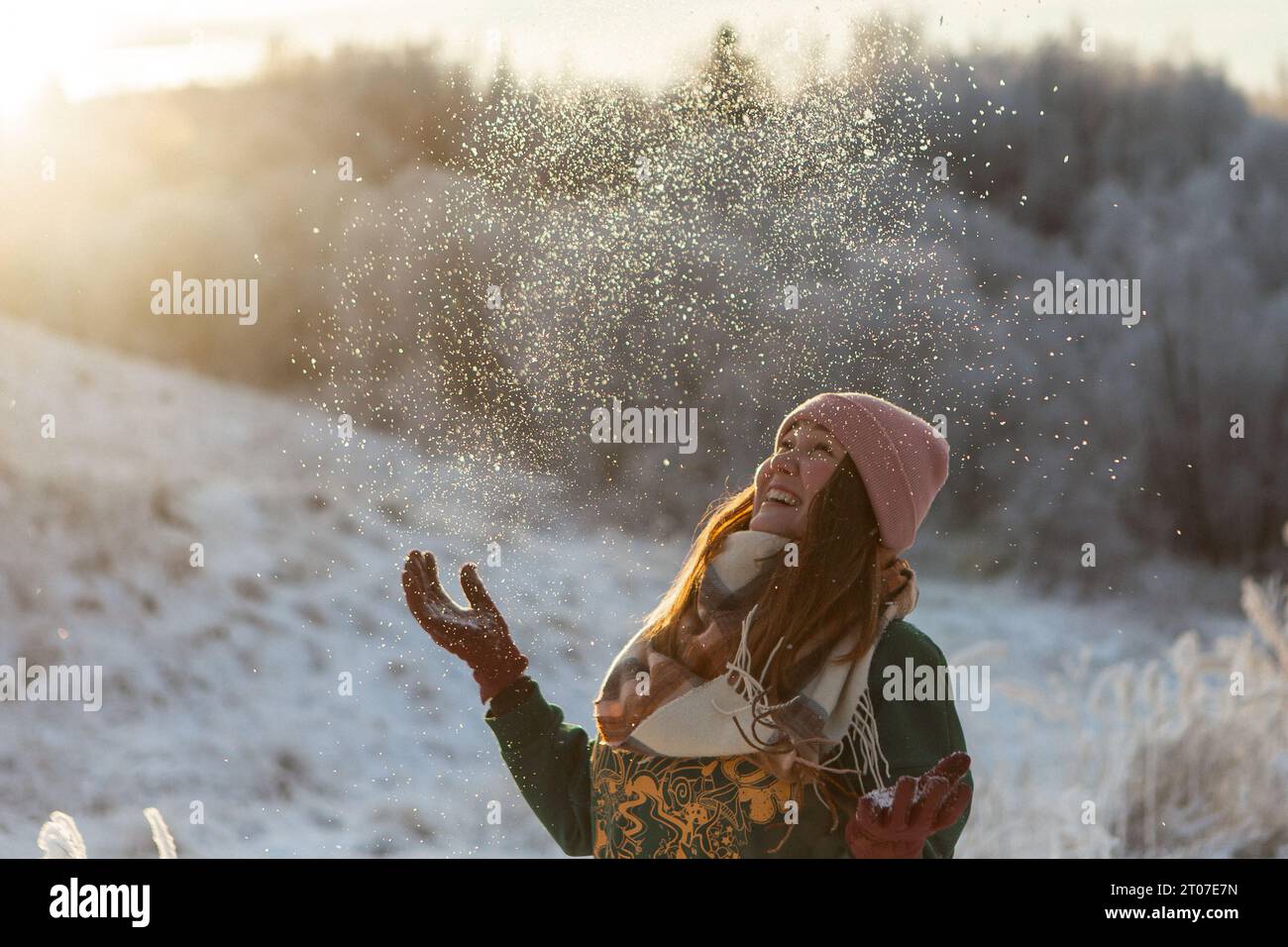 Porträt des glücklichen schönen Mädchens, der jungen freudigen positiven Frau, die mit Schnee, Schneeflocken, Spaß im Freien in Winterkleidung, Hut und Schal spielt, lächelnd. Wintersaison, Wetter. Hochwertige Fotos Stockfoto