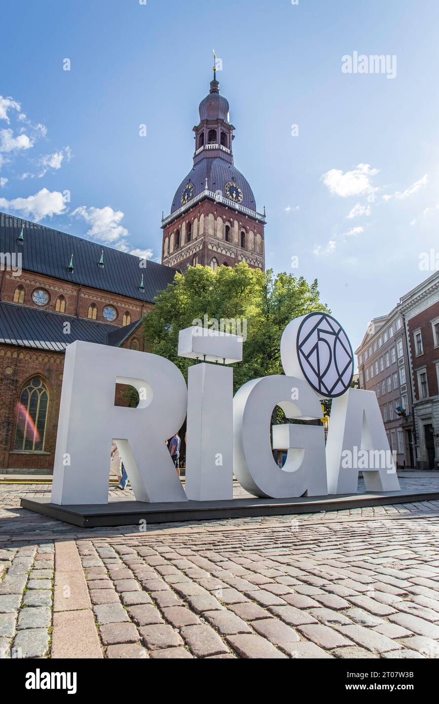 Riga, Lettland - 7. Juli 2023: Kuppelplatz mit Rigaer Kathedrale in der Altstadt mit Rigaer Schild davor Stockfoto