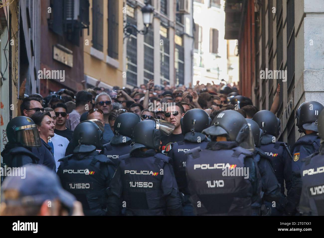 Feyenoord-Fans werden von der spanischen Nationalpolizei Stunden vor Beginn des Spiels gegen Atletico Madrid auf einer Straße im Zentrum Madrids begleitet. Fast 4.000 Ultras aus Feyenoord Rotterdam sind nach Madrid gereist, um die niederländische Mannschaft anzufeuern, die in der ersten Phase der UEFA Champions League im Stadion gegen Atletico de Madrid stand und in der der spanische Verein mit 3:2 gewann. Die Niederländer wurden immer von der spanischen Nationalpolizei begleitet. Fast 4.000 Ultras aus Feyenoord Rotterdam sind nach Madrid gereist, um die niederländische Mannschaft anzufeuern, die in t gegen Atletico de Madrid stand Stockfoto