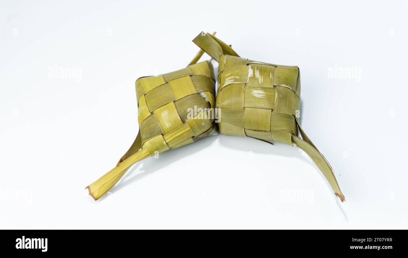 Ketupat ist immer noch in Kokosnussblätter eingewickelt, isoliert auf weißem Hintergrund Stockfoto