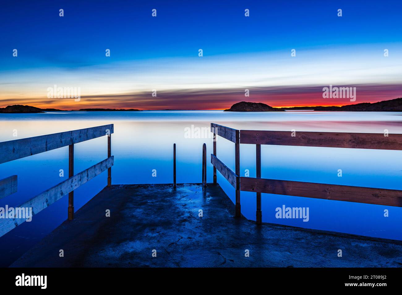 Ruhiger Sonnenuntergang über schwedischem Pier und Ozeanhorizont. Stockfoto